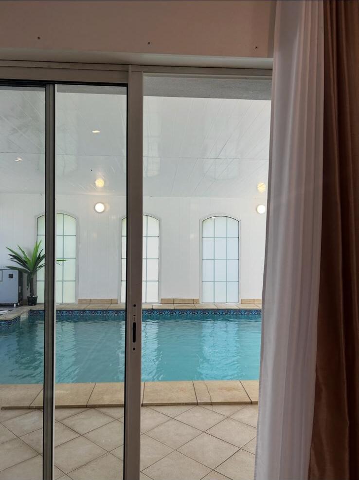 Salon ouvert sur la piscine intérieure
